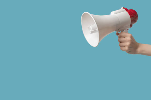 istock Megaphone in woman hands on a blue background. 1416468033