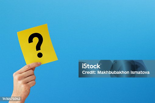 istock Question mark design. Hand holding note paper with question mark on blue background 1416475042
