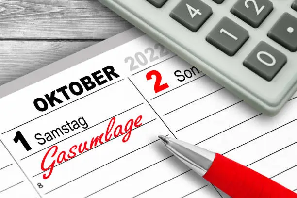 German calendar 2022 October 1  Saturday and calculator with red pencil