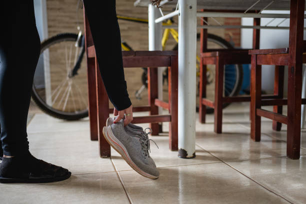 Yellow sneakers walking in mid-air against light blue background with copy space.