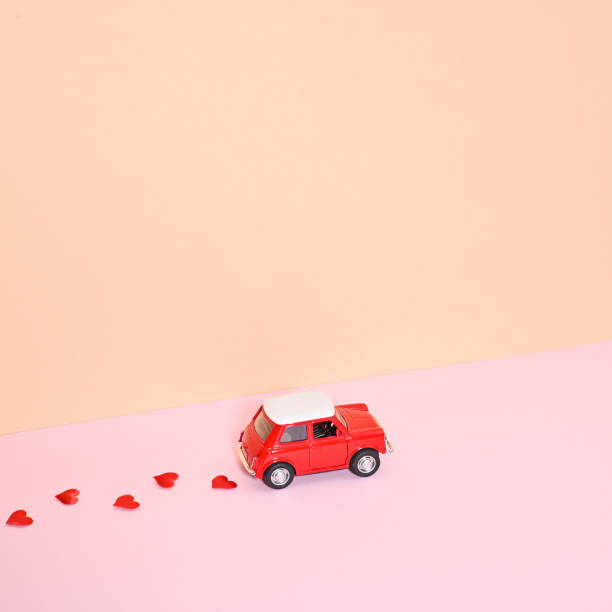 istock Little mini red car leave hearts behind. Romantic Valentine's day background. Copy space 1416478982