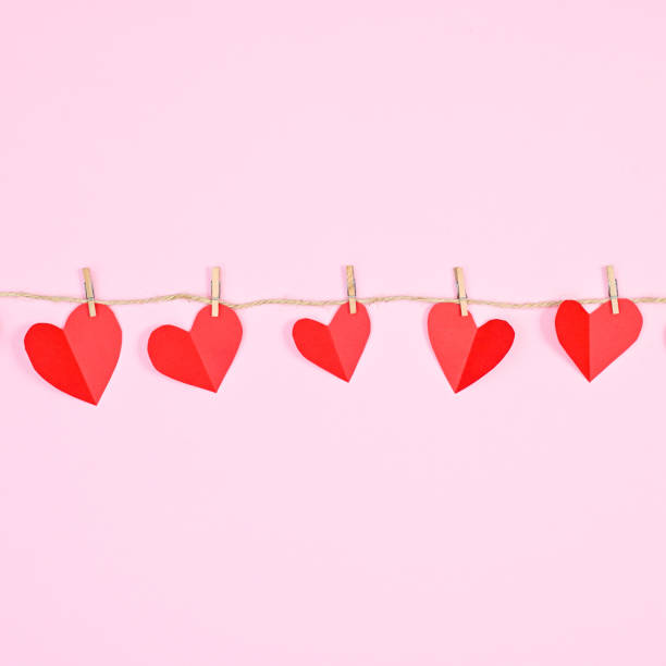 istock Creative hearts hanged on rope on pastel pink background. Creative Valentine's day concept 1416488649