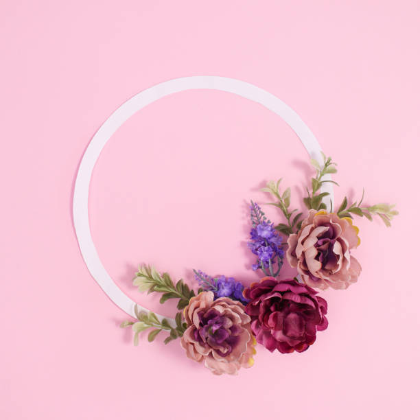 istock Copy space frame decorated with spring flowers on pastel pink background. Flat lay 1416497332