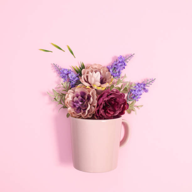 istock Pastel pink ceramic cup with spring flowers in it. Flat lay creative concept 1416497336