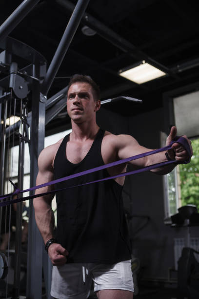 istock Sportsman training with resistance band at gym 1416503821