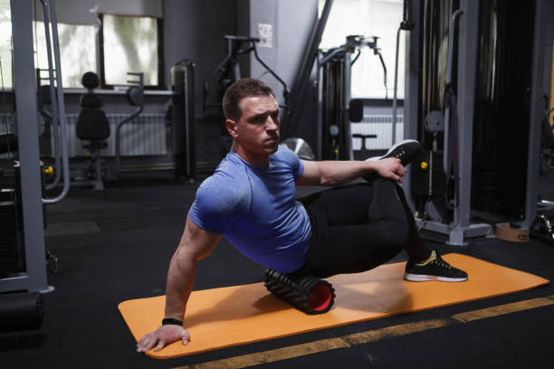 istock Male athlete using foam roller at the gym 1416505700