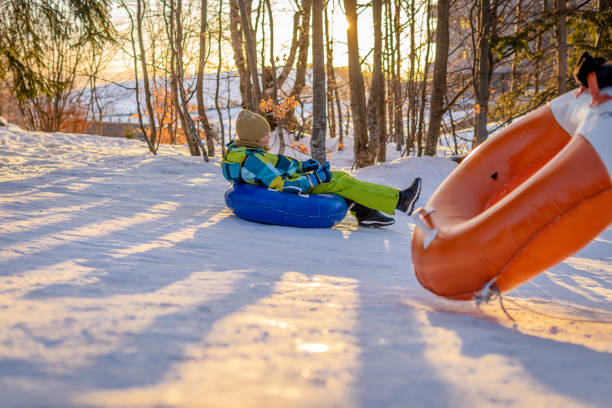 istock Child sledding down a hill on a snow tube 1416524240