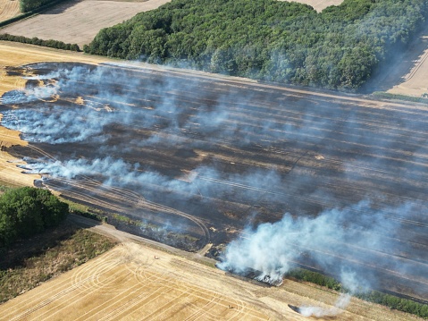 aerial view of extreme weather, drought and extreme heat cause wild wildfires in farm field, damage to crops and farm land and risk to farm animals