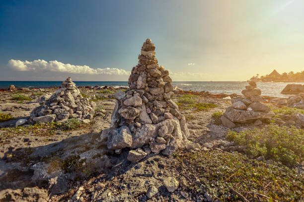 Stacks of zen rocks in Puerto Aventuras's Coast Stacks of zen rocks in the middle of the rocky coast of Puerto Aventuras in the Mayan Riviera in Mexico at sunset. puerto aventuras stock pictures, royalty-free photos & images