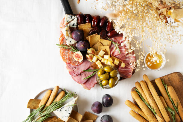 istock Meat, cheese and snackes plate, board and grissini on white background 1416538102