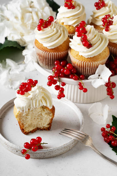 istock Vanilla cupcakes with red currant berries on plate on white 1416538110