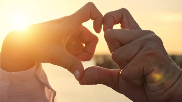 istock Disabled couple makes heart with hands at sunlight closeup 1416538215