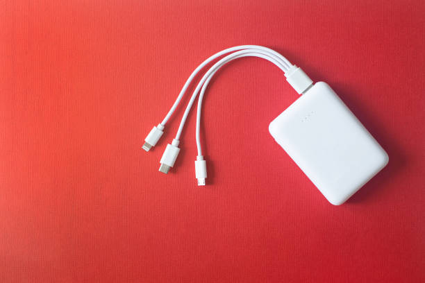 Powerbank on red background. Powerbank with different connectors. White power bank on red background. Powerbank with different connectors. External battery for different devices. mobile phone charger stock pictures, royalty-free photos & images