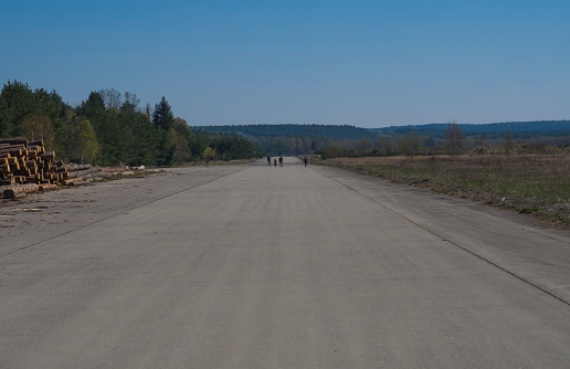 People using former soviet army military airport for having fun on in-line skates. Czech Republic, Ralsko. Springtime, blue sky