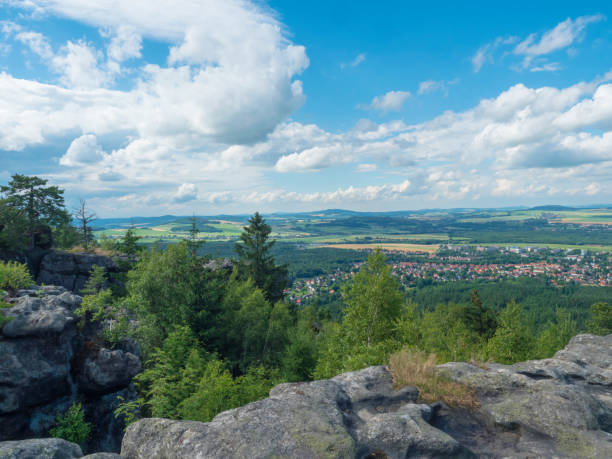 Tempelwand sandstone viewpoint next to hill Topfer near Oybin with view of Zittau town at Poland German borders in Zittauer Gebirge mountains, Saxony, germany. Summer sunny day, blue sky, white clouds. mirador de arenisca de tempelwand junto a la colina topfer cerca de oybin con vista de la ciudad de zittau en polonia fronteras alemanas en las montañas zittauer gebirge, sajonia, alemania. día soleado de verano, cielo azul, nubes blancas