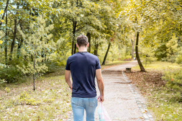 Caucasian guy walking on a footpath in the park
