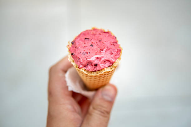 Image of strawberry ice cream cone in hand