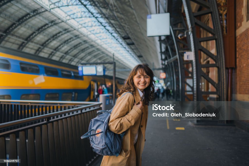 Woman waiting for the train on railway station Young Caucasian woman waiting for the train on railway station Morning Stock Photo