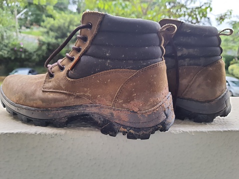 Hiking boot, isolated, stained with mud.