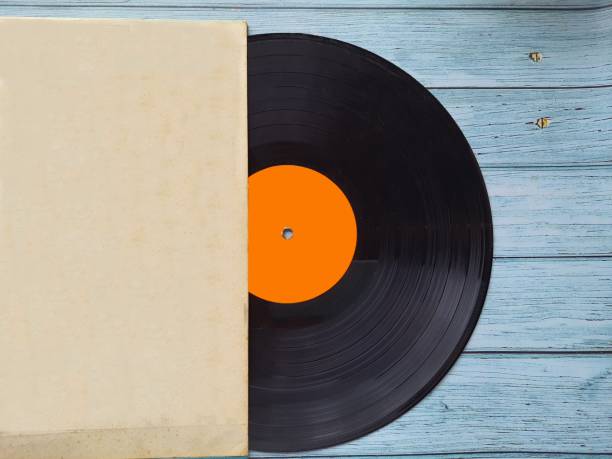 istock Vinyl record with cover on wooden table, top view. 1416553818