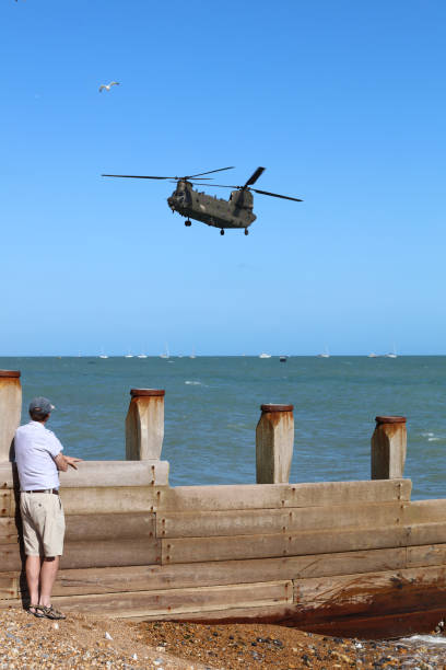 Chinook HC6A, Eastbourne Airbourne, International air show 2022 Eastbourne, UK - August 20, 2022: Chinook HC6A performing at the annual free Airbourne Air show and people watching on the beach. british aerospace stock pictures, royalty-free photos & images