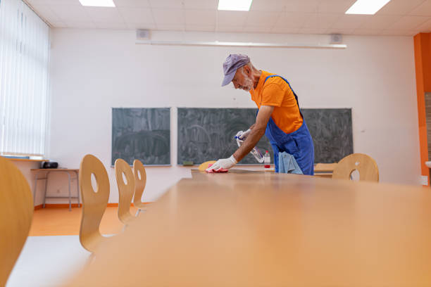 istock Janitor man wiping dust from desk 1416579244