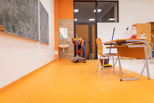 istock Janitor mops floor in school classroom 1416581108
