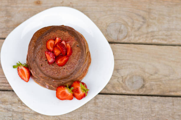 chocolate pancakes with strawberries on a white plate Copy space