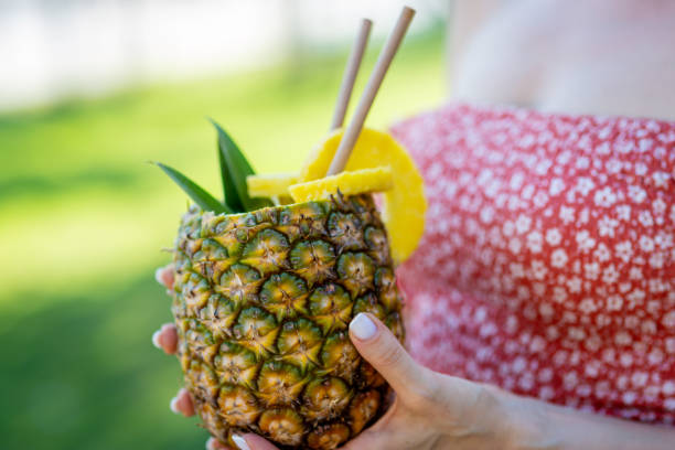 istock Young woman drinking fresh pineapple juice she just bought 1416597152