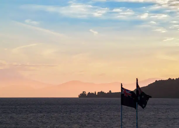 Dusk coloured sky over silhouette foreground of lake and hills