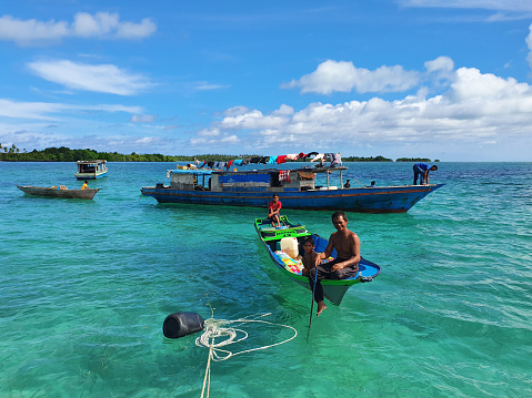Semporna, Malaysia - August 28, 2022: Sea gypsy or bajau laut man on a boat in the Celebes sea in Sabah Borneo Malaysia.