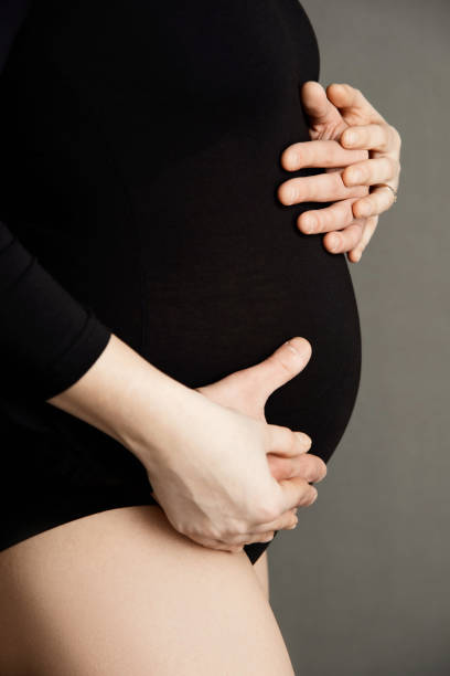 istock man and woman hands hugging pregnant belly 1416602949