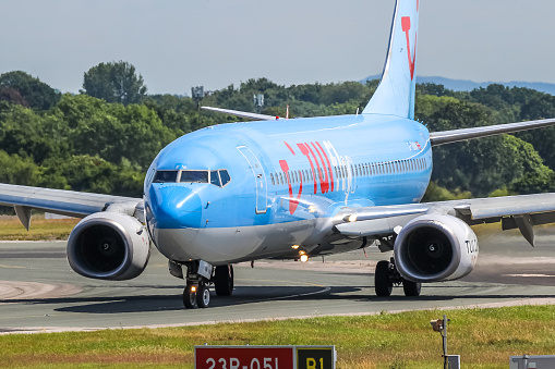 Manchester Airport, United Kingdom - 07 July, 2022: TUI Boeing 737 (G-TUKM) vacating runway 23R after landing.