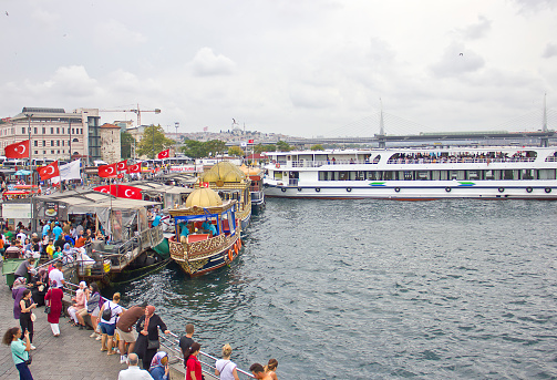 Istanbul,Turkey - August 10, 2022: Eminonu district with many facilities to eat such as floating restaurants and carts with fresh bakery, hot corn or roasted chestnuts in Istanbul, Turkey.
