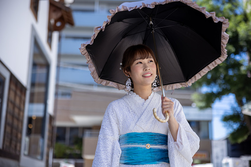 Japanese woman visiting traditional Japanese town. Renting a white lace kimono, eating Japanese food and shopping in retro style Japanese stores, etc.