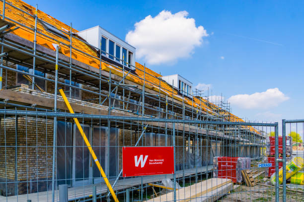 House under construction with a fence in front of it with van wanrooij sign, construction site in Rucphen, The Netherlands, 6 may, 2022 House under construction with a fence in front of it with van wanrooij sign, construction site in Rucphen, The Netherlands, 6 may, 2022 jetting stock pictures, royalty-free photos & images