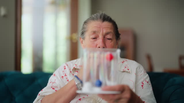 Senior woman using spirometer