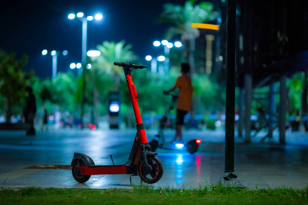 Rental electric scooter parked at night stock photo