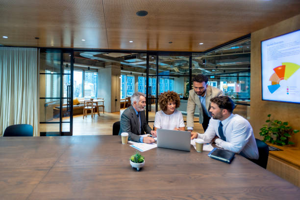 istock Four business people working on a laptop computer in an office conference room. 1416642969