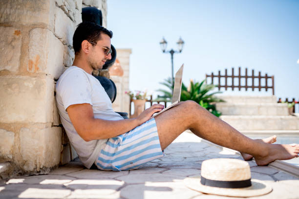 istock A man works on a laptop by the pool 1416653039