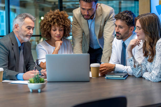 istock Five business people working on a laptop computer in an office conference room. 1416680577