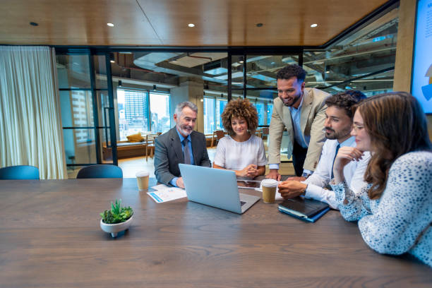 istock Five business people working on a laptop computer in an office conference room. 1416680584