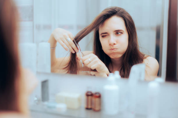 istock Puzzled Woman Trying to Cut her Bangs in the Mirror 1416681793