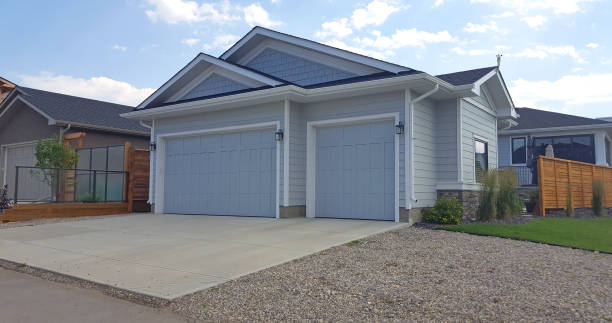 Calgary, Alberta, Canada- July 31,2022: Back alley with driveway and garage. Garage is for two cars plus an additional  single vehicle garage. Window on side. Decorative lights.  Detached from house.  Landscaped area around garage.
