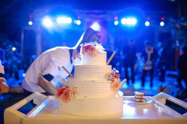 istock Beautiful happy couple cutting wedding cake 1416700085
