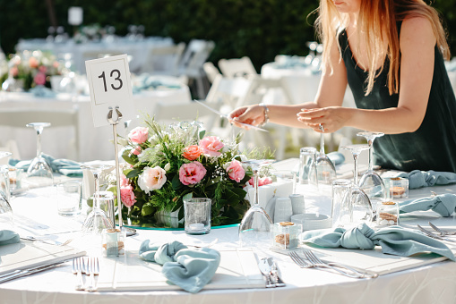 Shot of a young woman decorating a table with place card holders in preparation for a wedding reception