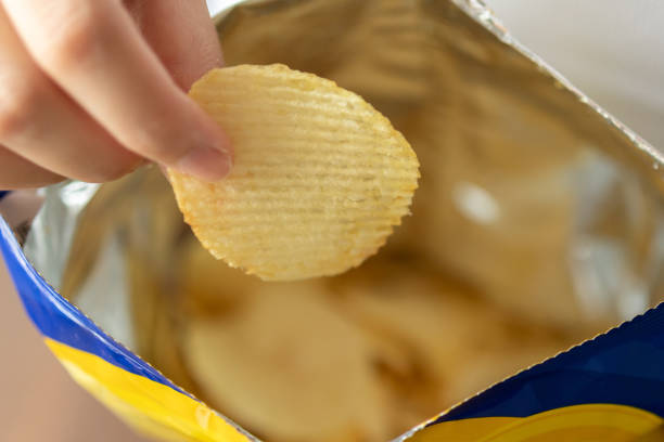 istock Hand hold potato chips with snack bag 1416702885