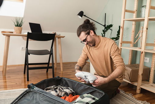 Portrait of a young couple packing a suitcase and preparing for a journey together