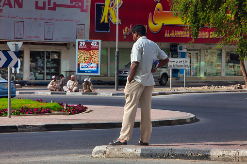 Doha, Qatar - January 26 2010 : during friday prayer guest workers are off and wait around on the street or play cricket