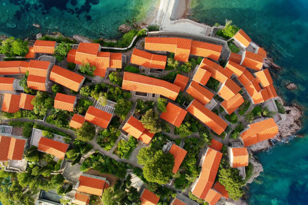 Amazing sunset aerial top drone view of Sveti Stefan island with historical town. Top down view of picturesque little island in Adriatic Sea located in Montenegro. stock photo